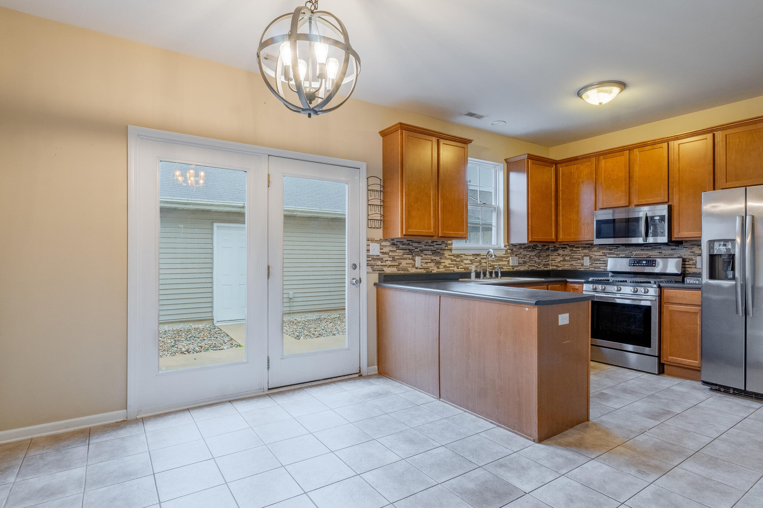 11742 Broadway Crown Point, IN 46307 - Photo 13 of 41 a kitchen with stainless steel appliances granite countertop a stove a sink and a refrigerator