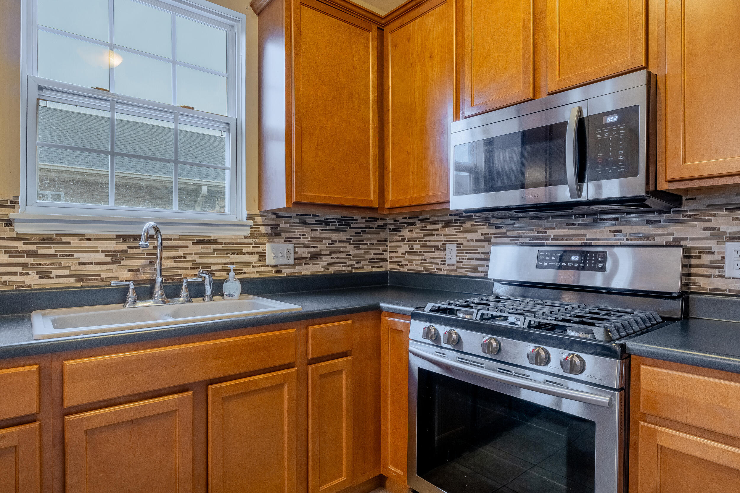 11742 Broadway Crown Point, IN 46307 - Photo 16 of 41 a kitchen with stainless steel appliances granite countertop a sink stove and microwave