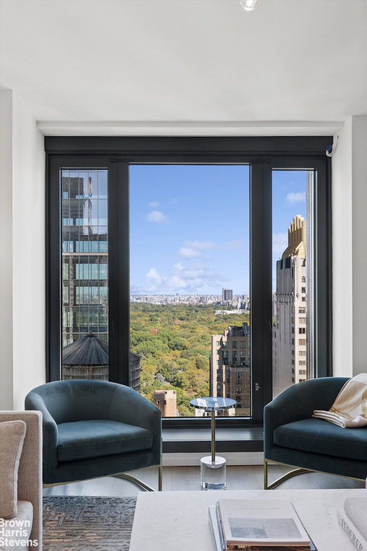 111 West 56th Street, Unit 38L Manhattan, NY 10019 - Photo 1 of 12 a living room with furniture and a floor to ceiling window
