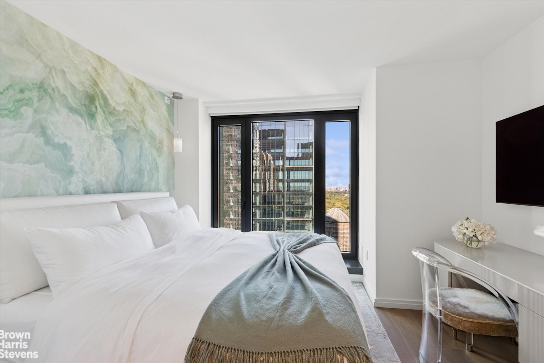 111 West 56th Street, Unit 38L Manhattan, NY 10019 - Photo 5 of 12 a bedroom with a bed and a flat screen tv