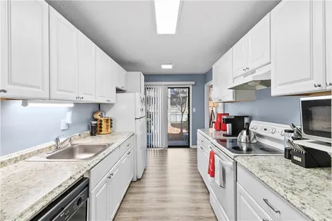 a kitchen with granite countertop lots of counter top space appliances and cabinets