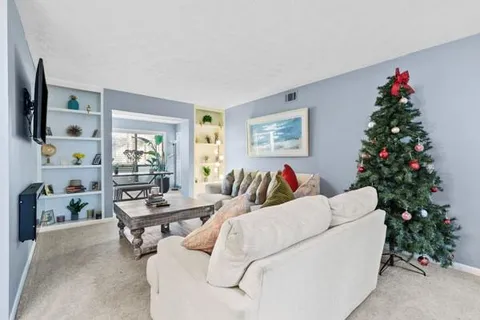a living room with furniture and a christmas tree