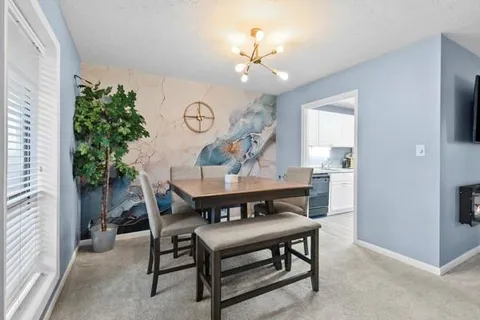a view of a dining room with furniture and a chandelier