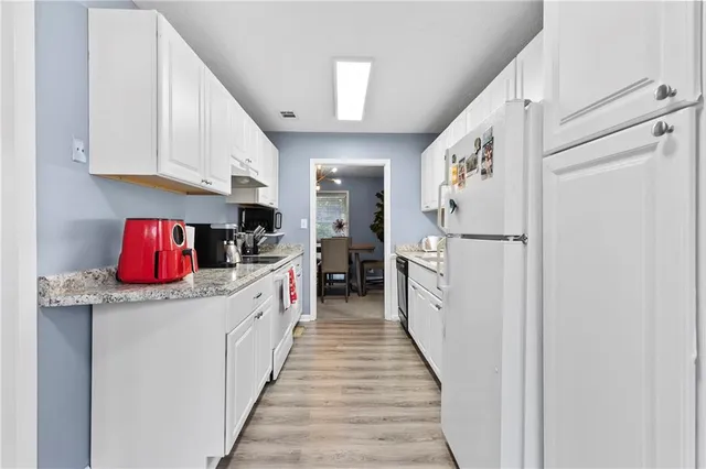 a kitchen with stainless steel appliances granite countertop a refrigerator a stove and a sink