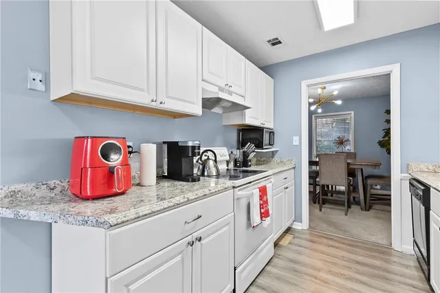 a kitchen with granite countertop a white cabinets and sink