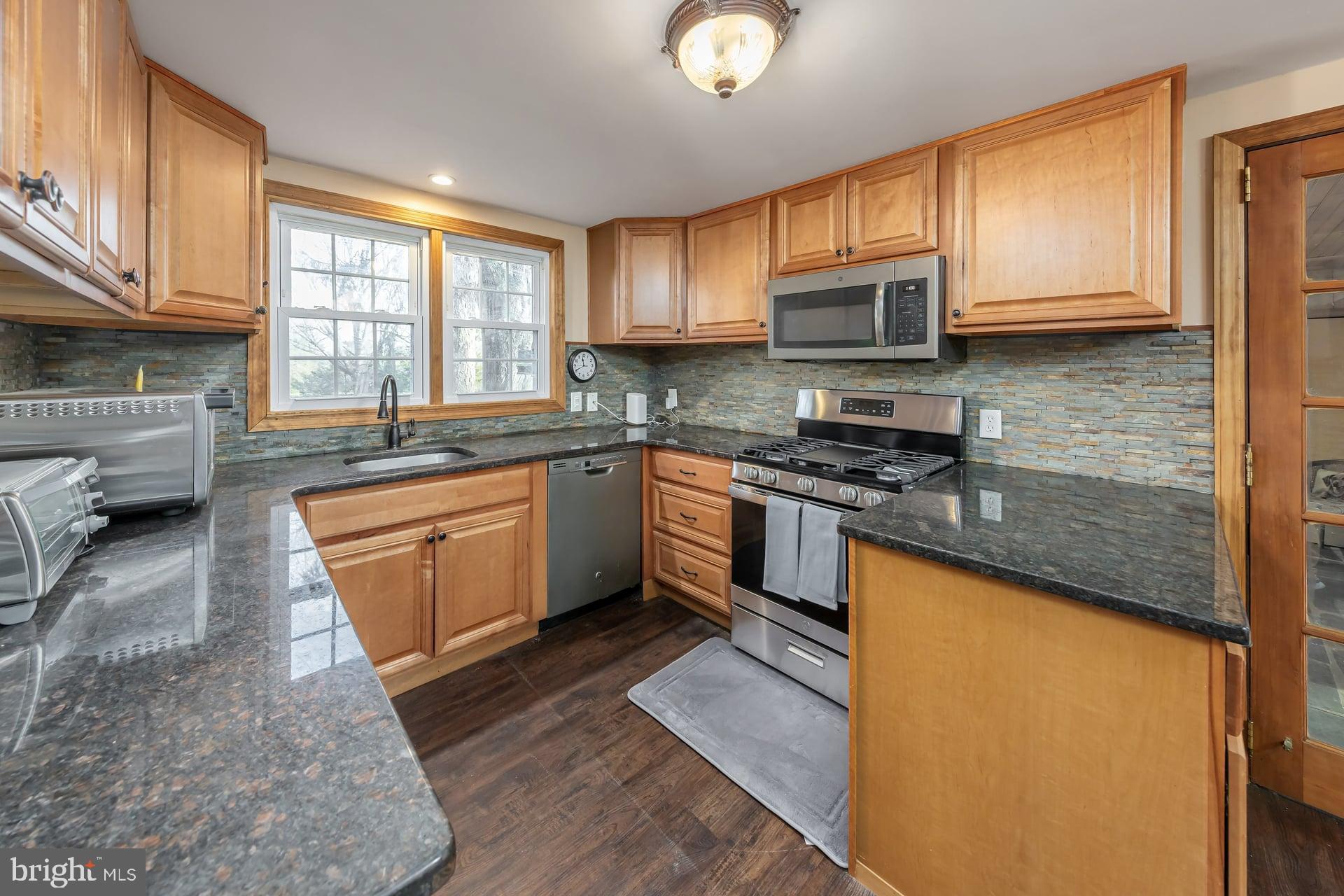 41 Hackett Road Woodstown, NJ 08098 - Photo 11 of 67 a kitchen with stainless steel appliances granite countertop wooden cabinets a stove top oven a sink and dishwasher