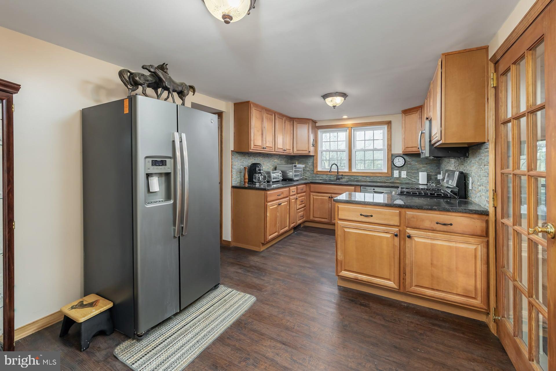 41 Hackett Road Woodstown, NJ 08098 - Photo 9 of 67 a kitchen with stainless steel appliances granite countertop a refrigerator a sink dishwasher a stove with wooden cabinets and floor