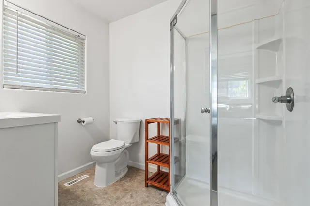 a bathroom with a toilet and a shower