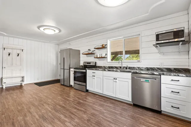 a kitchen with granite countertop stainless steel appliances and wooden cabinets