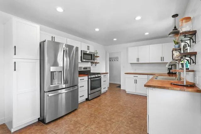 a kitchen with granite countertop a refrigerator and a sink