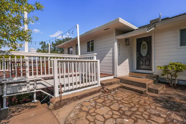 a view of a house with backyard and sitting area