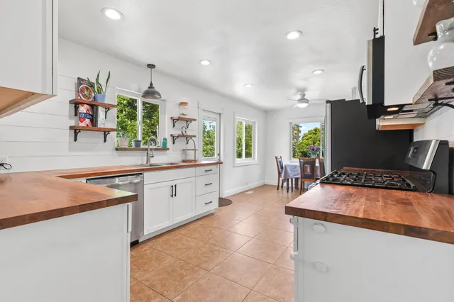 a kitchen with stainless steel appliances granite countertop a sink counter space and a window