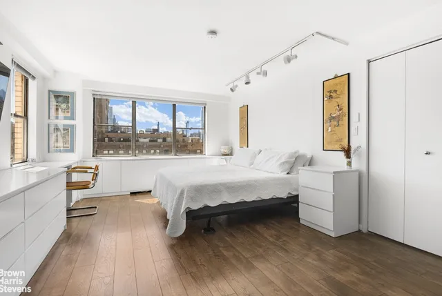 a bedroom with a bed and a large window