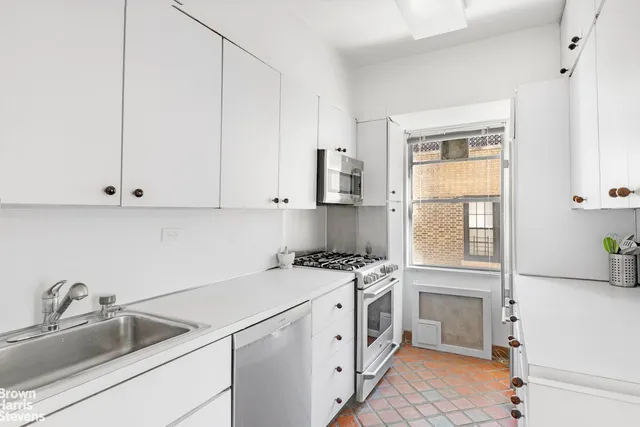 a kitchen with a sink stove top oven and cabinets