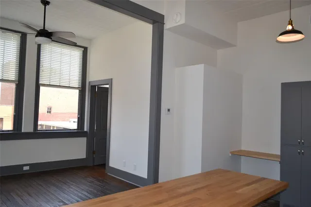 a view of hallway with window and wooden floor