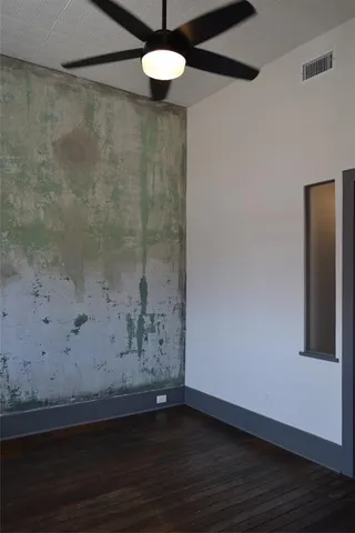 a view of wooden floor and chandelier fan in a room