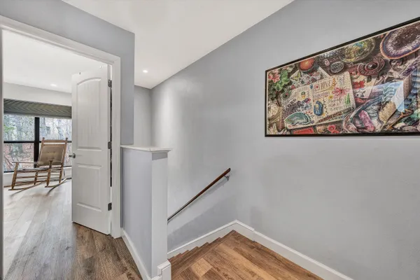 a view of a hallway with wooden floor and workspace