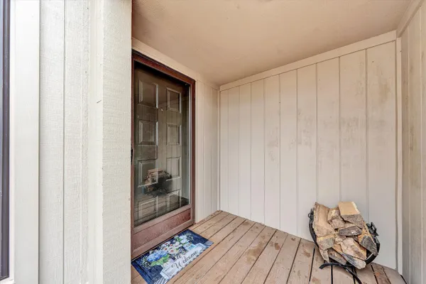 a view of a hallway with wooden floor and a bedroom