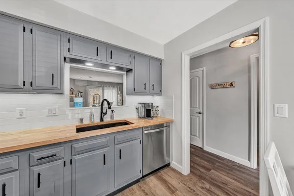 a kitchen with a sink cabinets and wooden floor