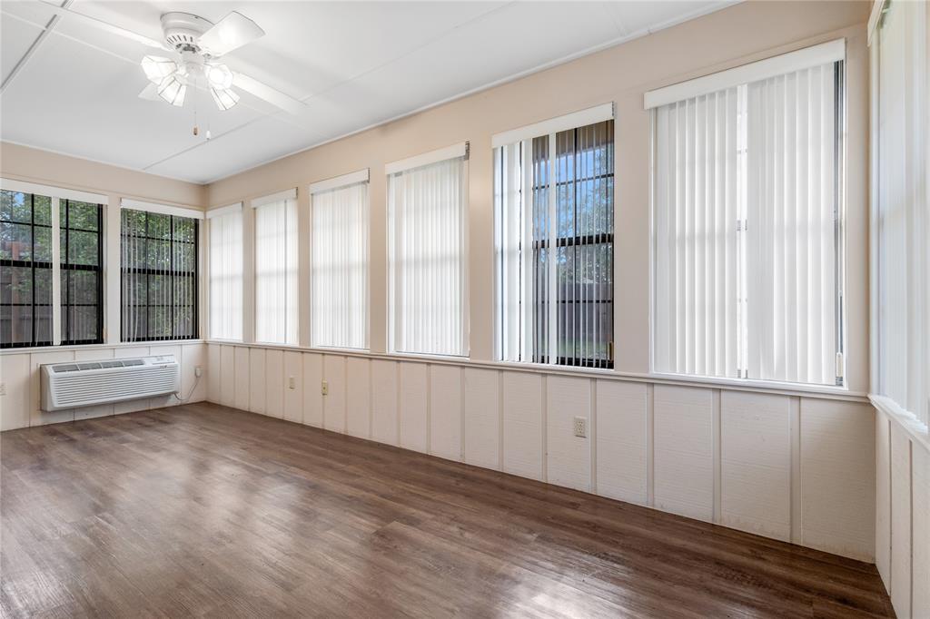 1609 Robin Street Mineola, TX 75773 - Photo 10 of 24 Room featuring wood-finish flooring, white paneling, and multiple windows