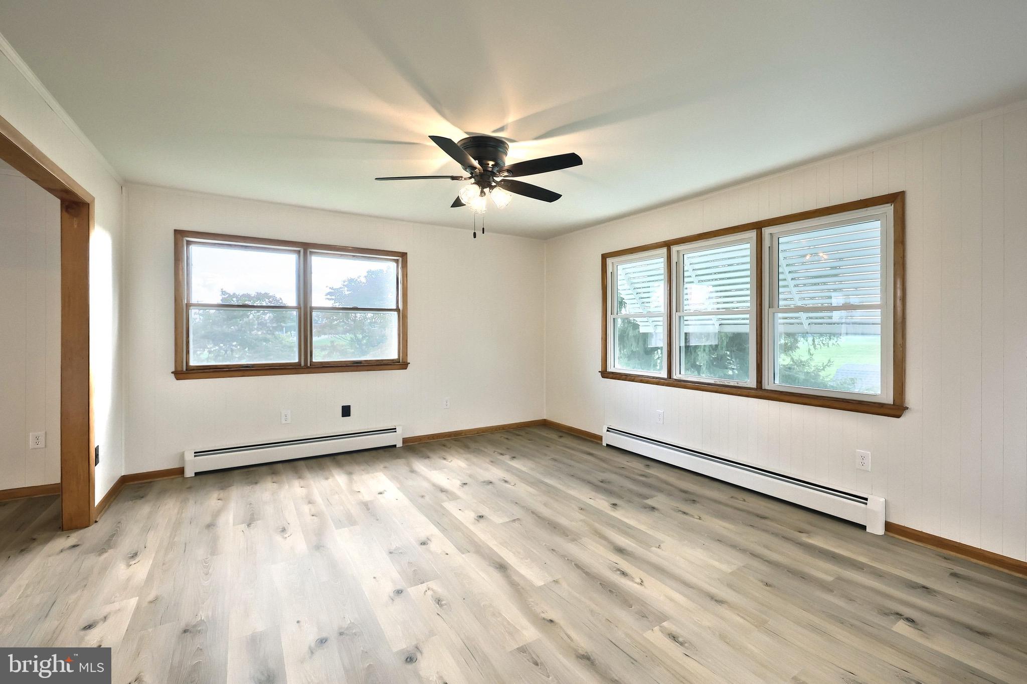 1825 White Hall Road Littlestown, PA 17340 - Photo 57 of 89 an empty room with wooden floor chandelier fan and windows