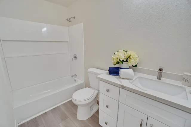 a bathroom with a granite countertop sink a toilet and shower