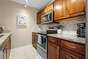a kitchen with granite countertop stainless steel appliances a stove microwave and sink