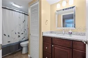 a bathroom with a granite countertop sink toilet and shower