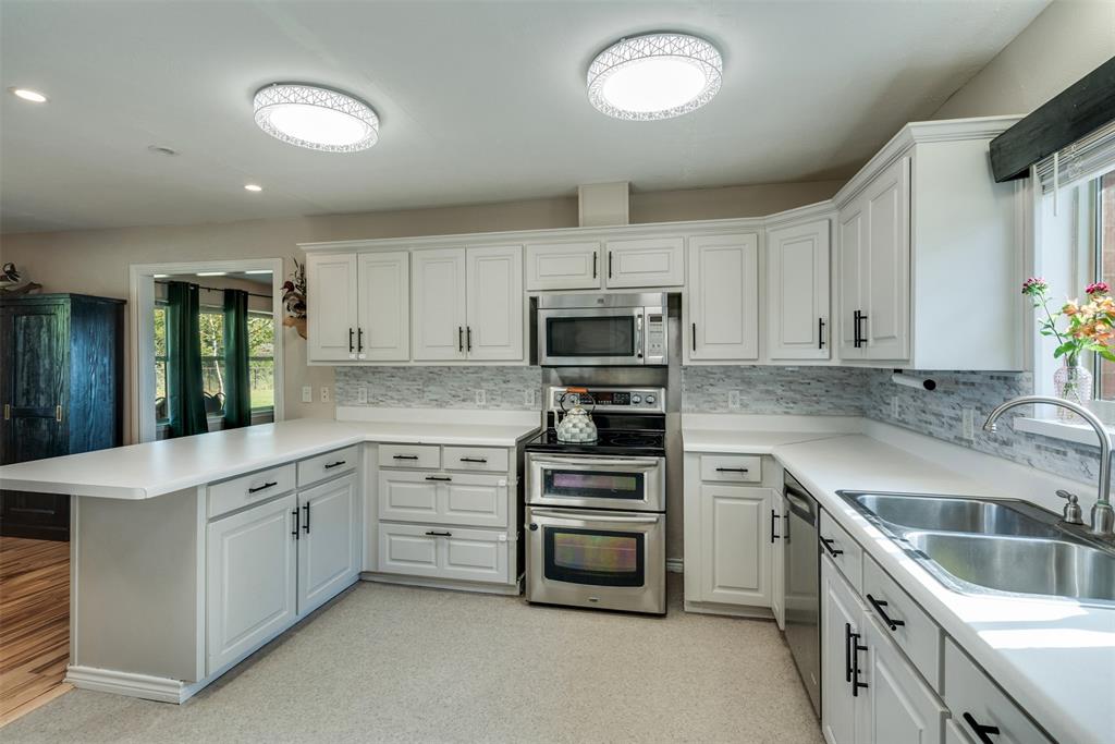 917 Cole Lane Sunset, TX 76270 - Photo 12 of 40 a kitchen that has a sink and cabinets in it