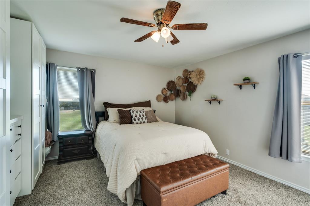 917 Cole Lane Sunset, TX 76270 - Photo 13 of 40 a bedroom with a bed and a chandelier