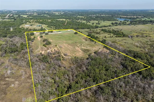an aerial view of residential houses with outdoor space and trees