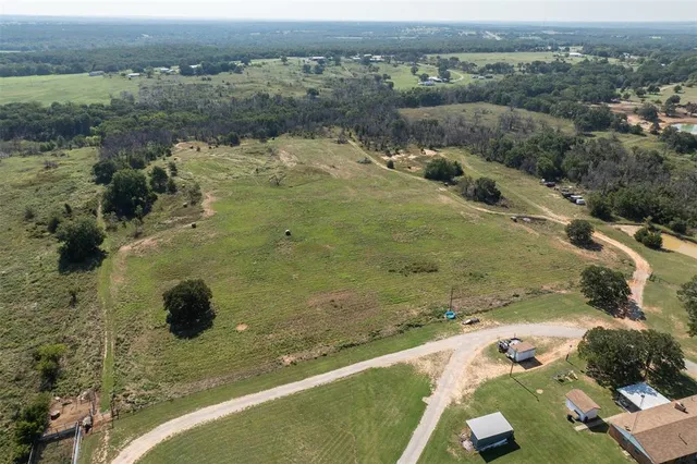 an aerial view of a house with a yard and lake view