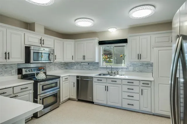 a kitchen with stainless steel appliances granite countertop a stove sink and cabinets