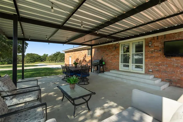 a view of a porch with furniture and a backyard