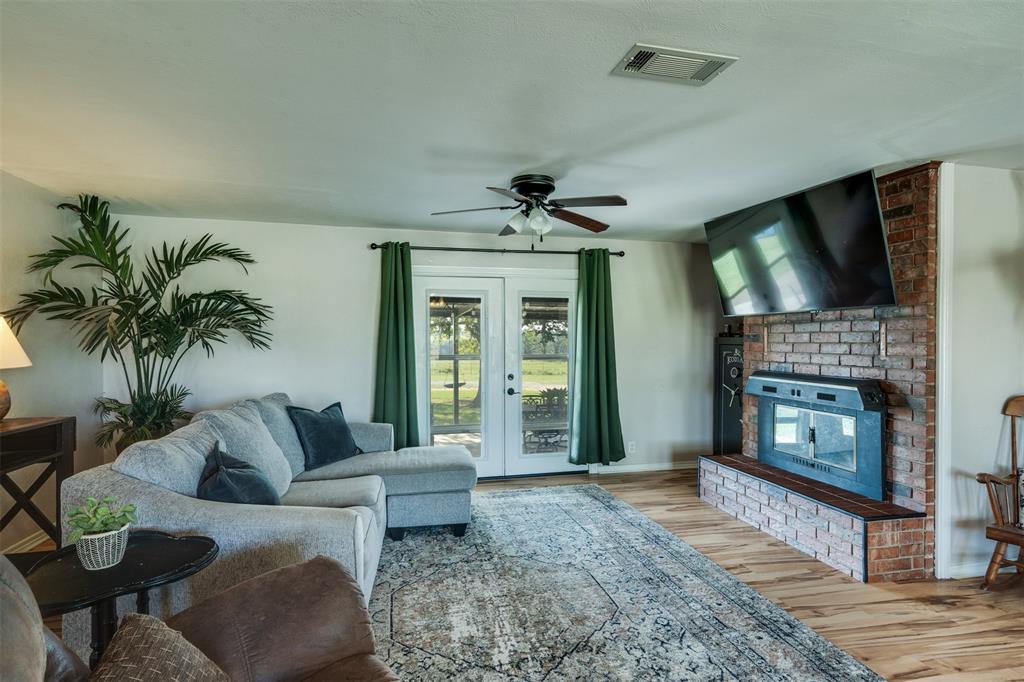 917 Cole Lane Sunset, TX 76270 - Photo 10 of 40 a living room with furniture a flat screen tv and a fireplace
