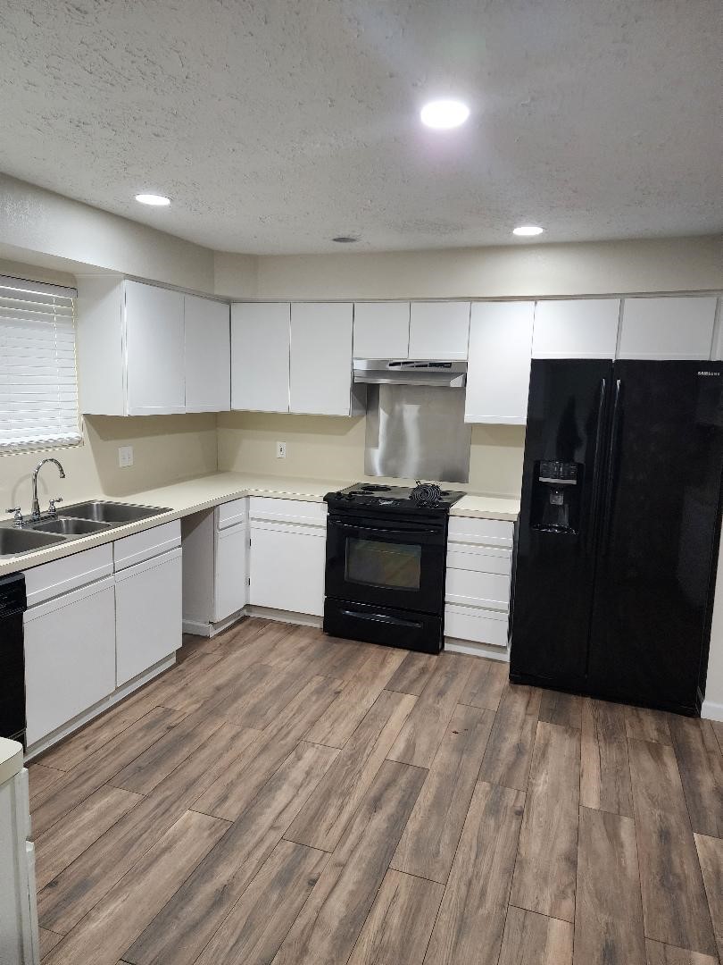 711 Leicester Lane Houston, TX 77034 - Photo 5 of 16 a kitchen with a refrigerator and a stove top oven