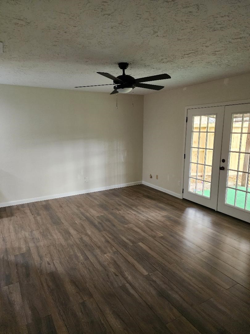 711 Leicester Lane Houston, TX 77034 - Photo 8 of 16 an empty room with wooden floor fan and windows