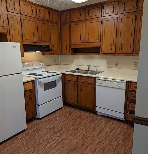 5358 Ridgemere Court Stone Mountain, GA 30083 - Photo 4 of 9 a kitchen with stainless steel appliances granite countertop wooden cabinets a sink and dishwasher with wooden floor