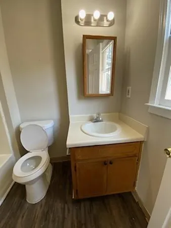 a bathroom with a toilet sink and mirror