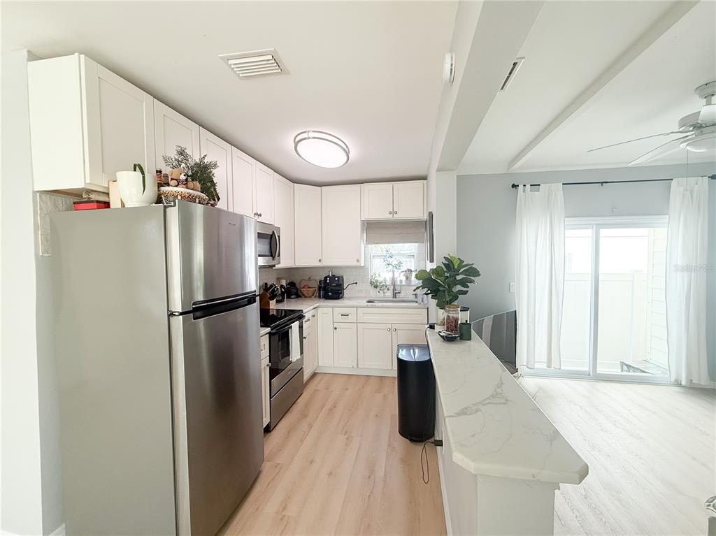 175 133rd Avenue East, Unit WEST Madeira Beach, FL 33708 - Photo 5 of 15 a kitchen with a refrigerator a sink and dishwasher