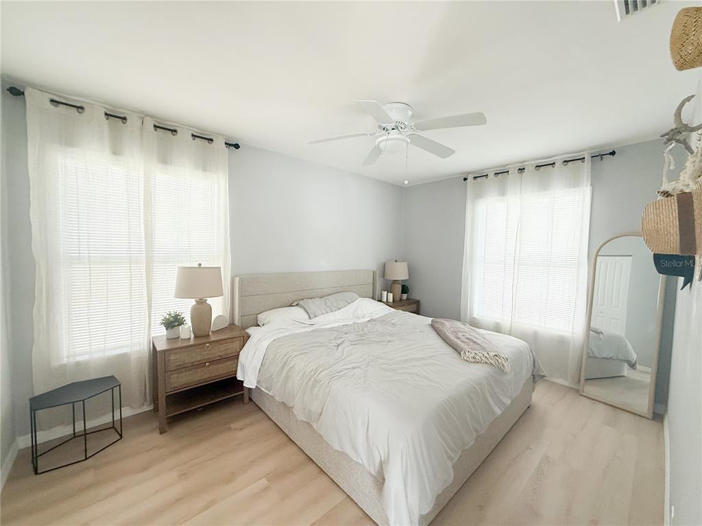 175 133rd Avenue East, Unit WEST Madeira Beach, FL 33708 - Photo 6 of 15 a bedroom with a bed mirror and window