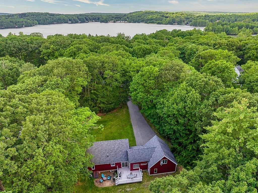 an aerial view of a house with pool and lake view