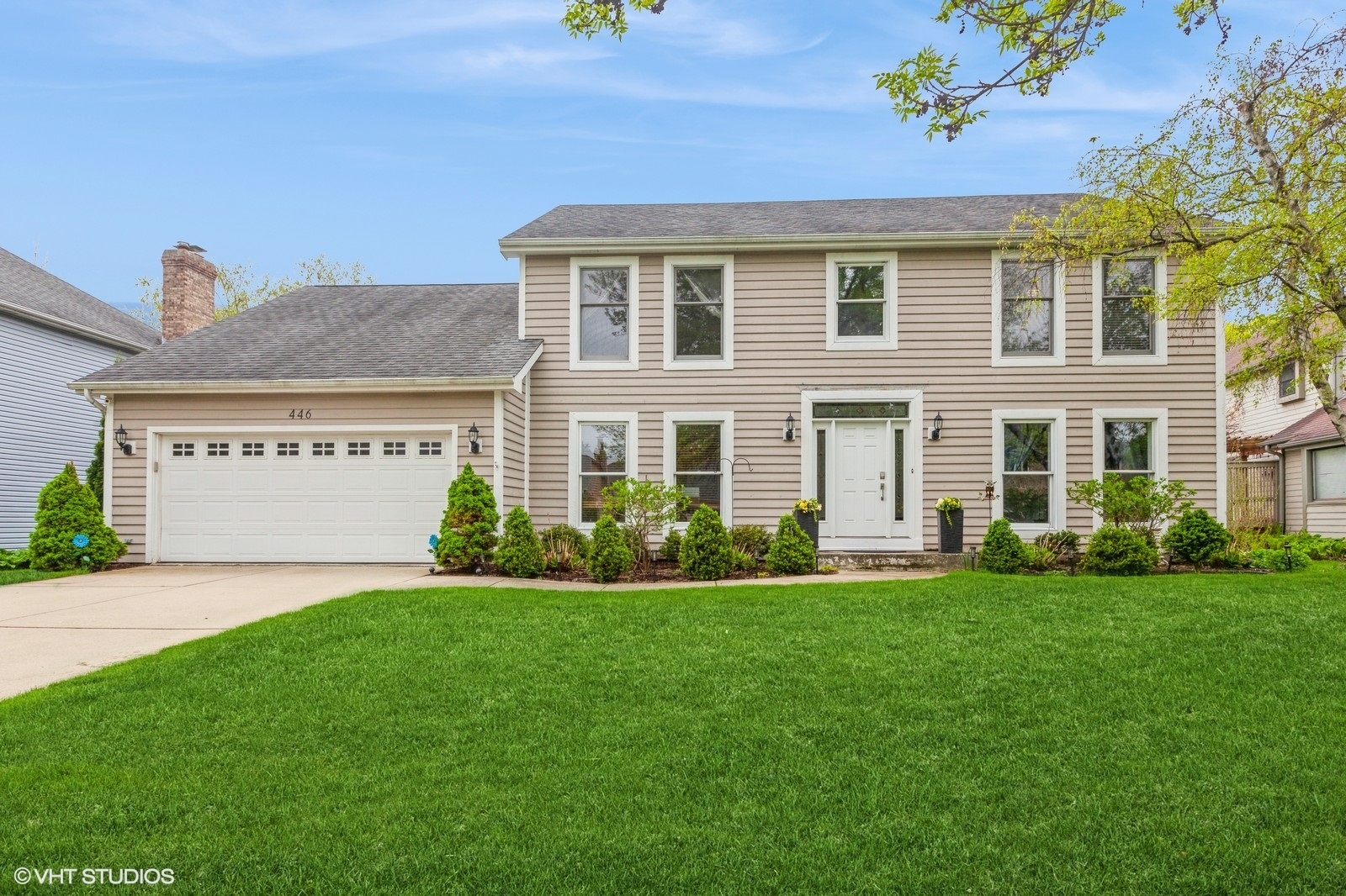 a front view of a house with a garden and yard