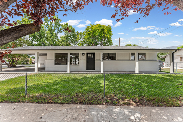 1898 West 600 South Provo, UT 84601 - Photo 28 of 32 White exterior residence featuring a covered carport, dark framed windows, a black entry door, and a manicured lawn