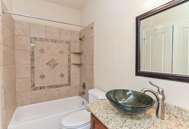 a bathroom with a granite countertop tub toilet and a sink