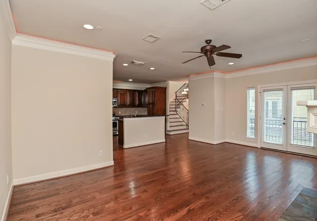 a view of a big room with wooden floor and a kitchen