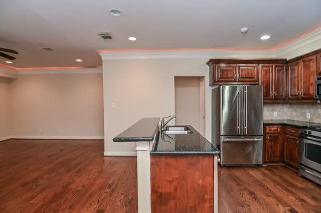a kitchen with stainless steel appliances granite countertop a refrigerator and a stove