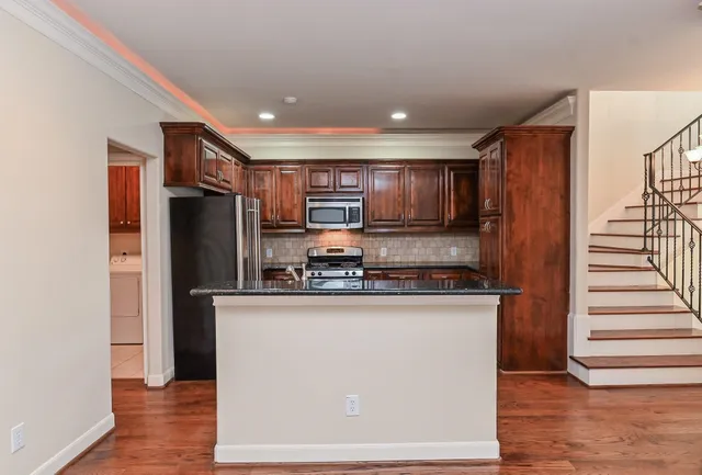 a kitchen with stainless steel appliances granite countertop a refrigerator and a stove top oven