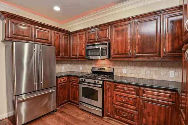 a kitchen with granite countertop stainless steel appliances and wooden cabinets