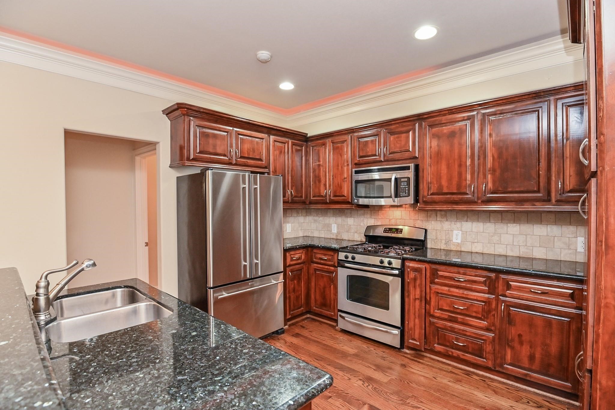 5813 Washington Avenue, Unit B Houston, TX 77007 - Photo 6 of 36 a kitchen with stainless steel appliances granite countertop a refrigerator stove and sink